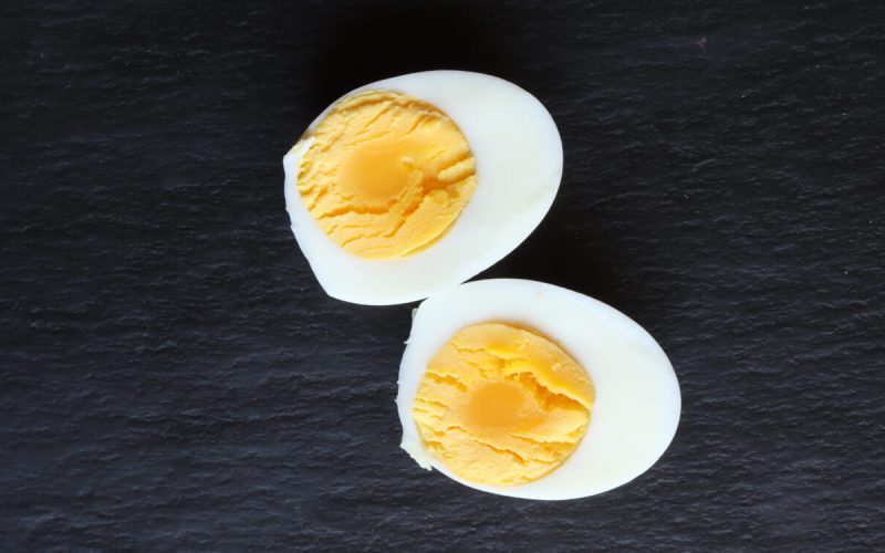 Photography of a cut hard-boilled egg on a slate for food background